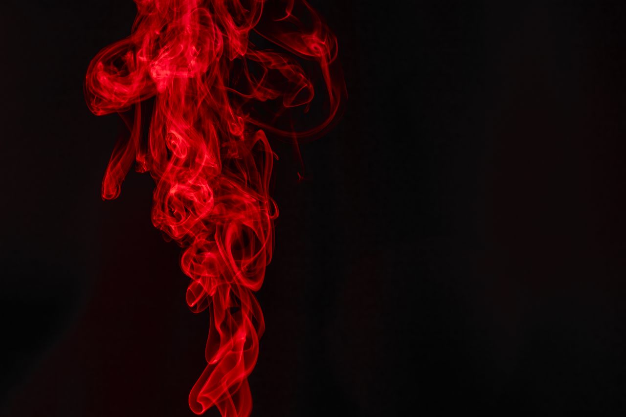 services-01 An artistic display of vibrant red smoke swirling elegantly set against a dark backdrop, creating a dynamic abstract composition.